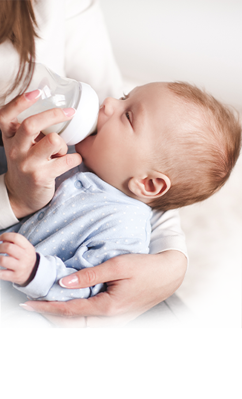 a woman feeding a baby with a bottle
